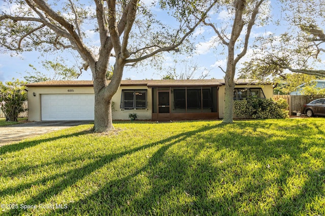 ranch-style house featuring a garage, a sunroom, and a front yard