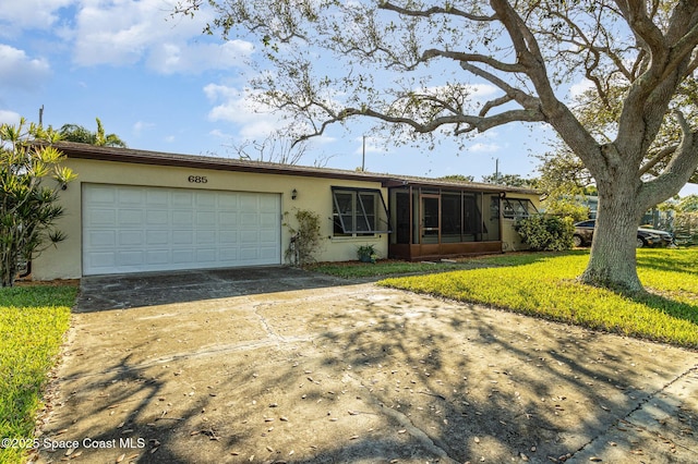 single story home with a garage, a sunroom, and a front yard