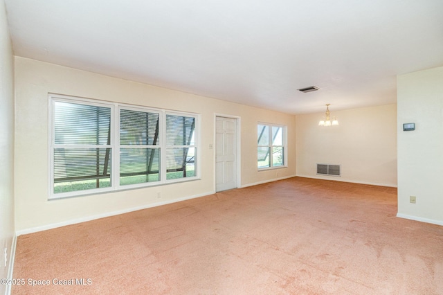 unfurnished living room featuring light colored carpet and a chandelier