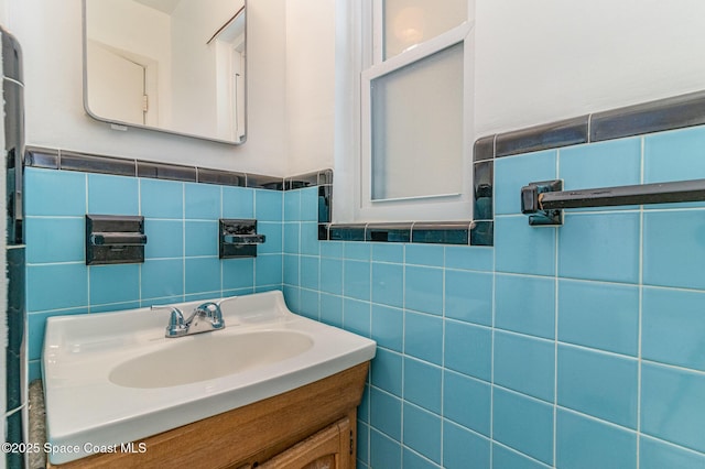 bathroom featuring vanity and tile walls