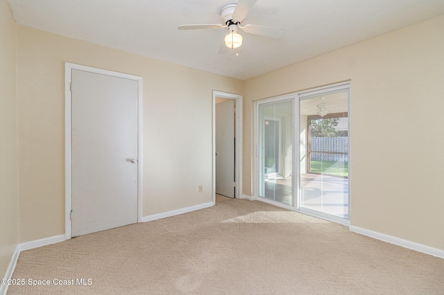 spare room featuring light carpet and ceiling fan