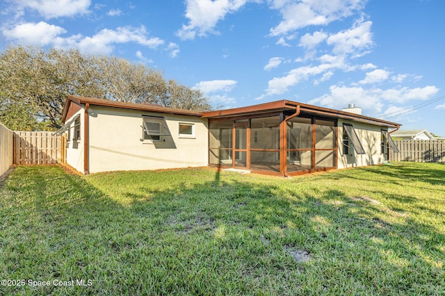 rear view of property featuring a sunroom and a lawn