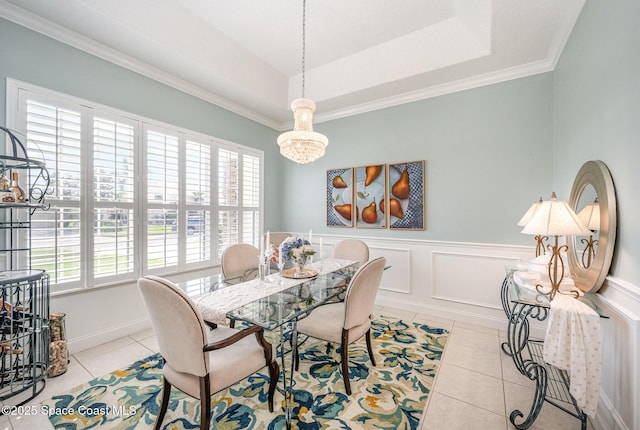 dining area featuring ornamental molding, light tile patterned floors, and a tray ceiling