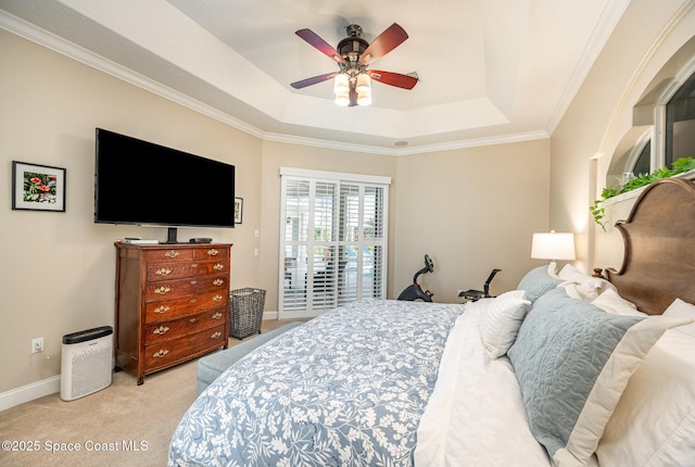 bedroom with a raised ceiling, light carpet, and ceiling fan