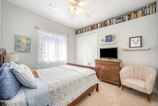 bedroom with light colored carpet, a closet, and ceiling fan