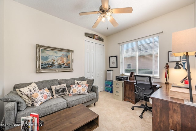 carpeted office with a textured ceiling and ceiling fan