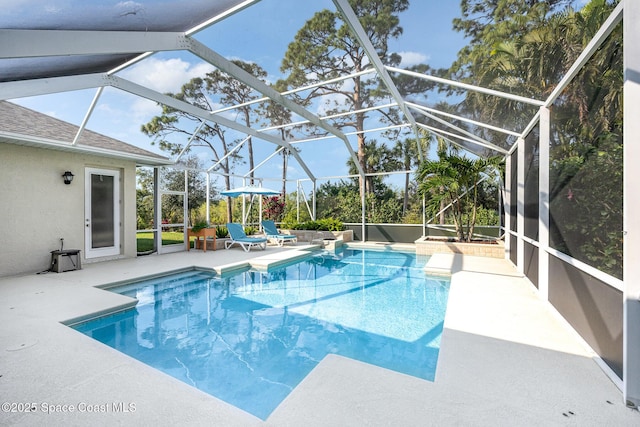 view of swimming pool featuring a lanai and a patio area