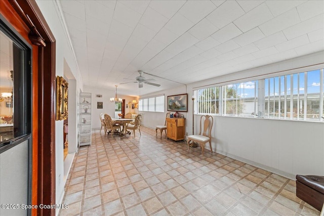 unfurnished sunroom with ceiling fan with notable chandelier