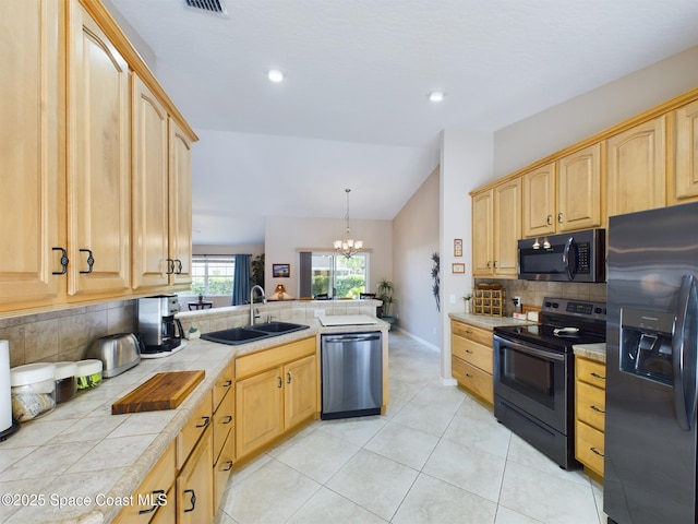 kitchen with sink, appliances with stainless steel finishes, backsplash, hanging light fixtures, and tile counters