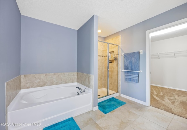 bathroom featuring tile patterned floors, independent shower and bath, and a textured ceiling