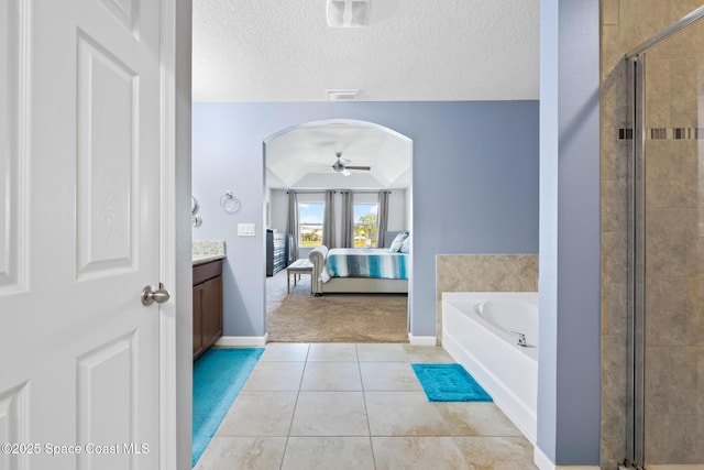 bathroom featuring a textured ceiling, vanity, independent shower and bath, ceiling fan, and tile patterned flooring