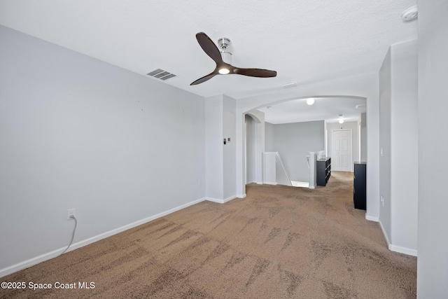 unfurnished room featuring ceiling fan and carpet