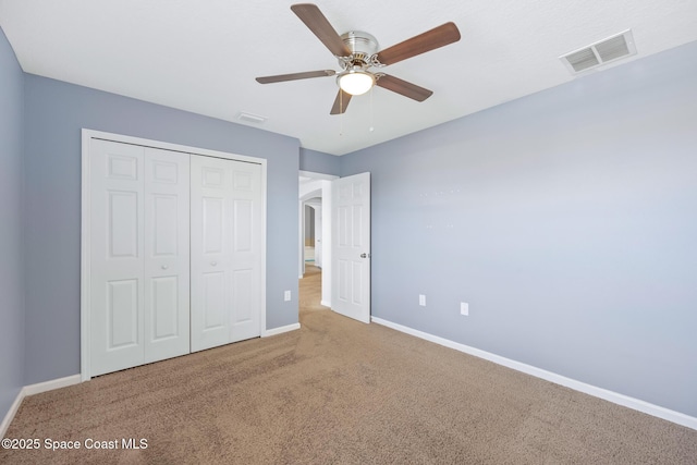 unfurnished bedroom featuring carpet floors, a closet, and ceiling fan