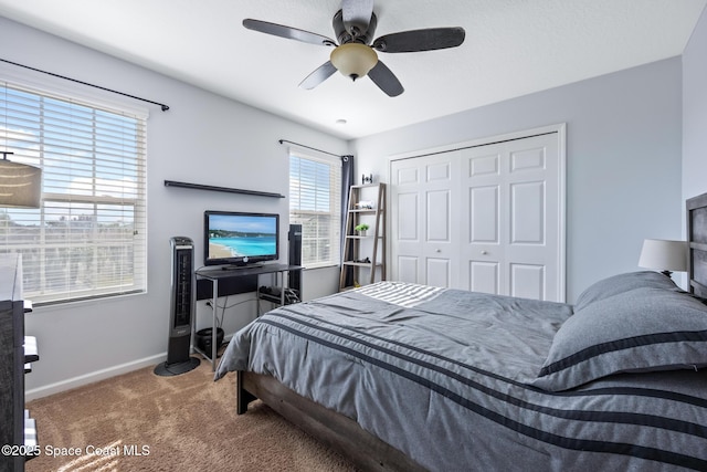 carpeted bedroom featuring ceiling fan and a closet