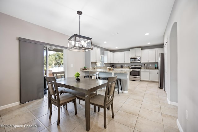 tiled dining room featuring an inviting chandelier