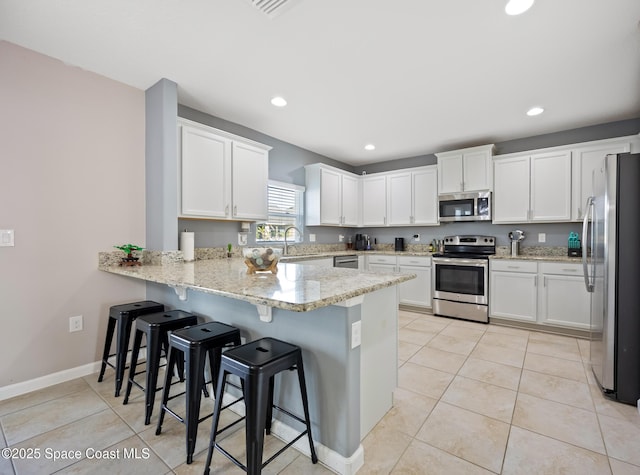 kitchen featuring sink, light tile patterned flooring, white cabinets, and appliances with stainless steel finishes