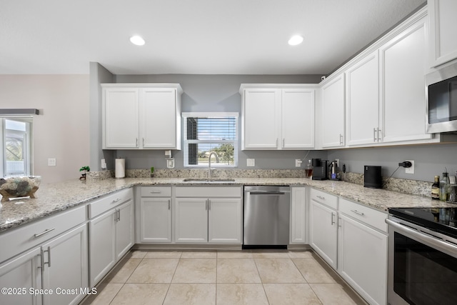 kitchen featuring white cabinetry, sink, stainless steel appliances, and light stone countertops