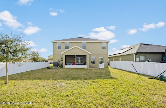 rear view of property with central AC and a lawn