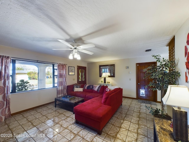 living room featuring ceiling fan and a textured ceiling