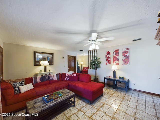 living room with ceiling fan and a textured ceiling