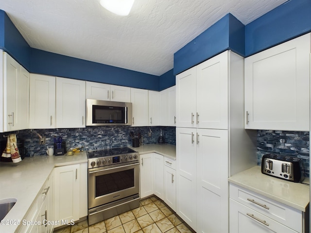 kitchen with white cabinetry, appliances with stainless steel finishes, tasteful backsplash, and a textured ceiling