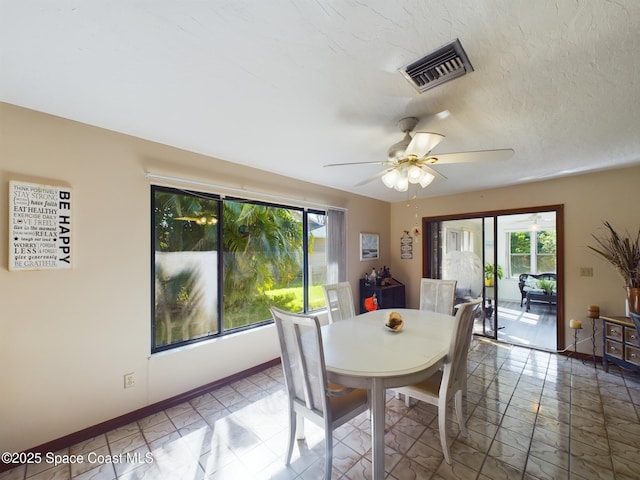 dining area featuring ceiling fan and a textured ceiling