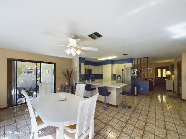 dining space with a healthy amount of sunlight, sink, and ceiling fan