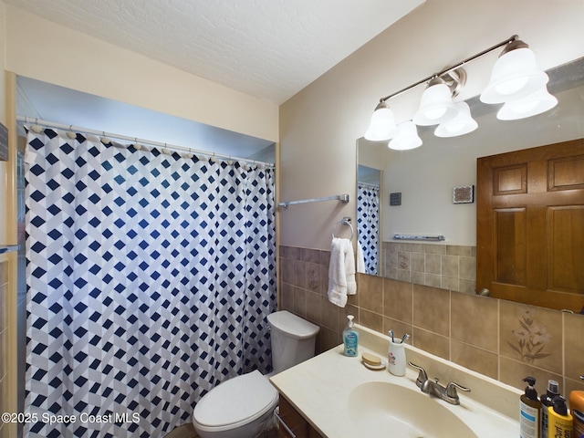 bathroom featuring a shower with curtain, vanity, toilet, and tile walls