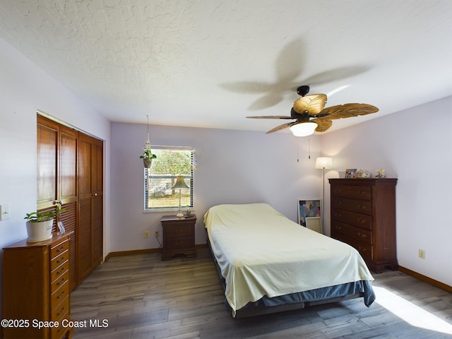 bedroom featuring ceiling fan, a closet, dark hardwood / wood-style flooring, and a textured ceiling