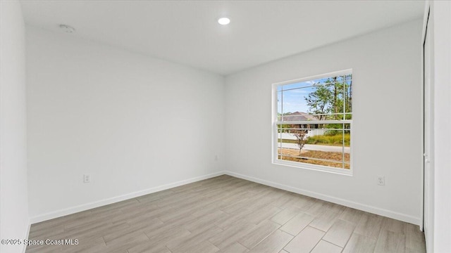 unfurnished room featuring recessed lighting, light wood finished floors, and baseboards