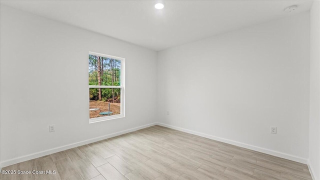 spare room with light wood-style flooring and baseboards