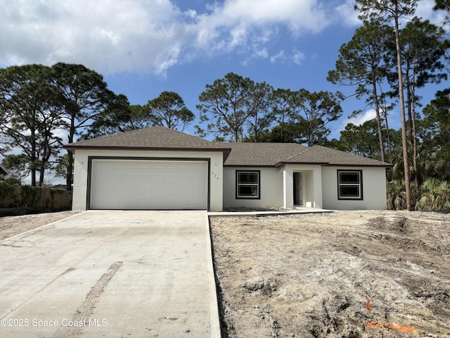 single story home with a garage, driveway, and stucco siding