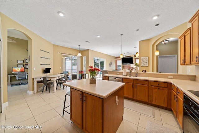 kitchen with black oven, a center island, a kitchen bar, decorative light fixtures, and kitchen peninsula