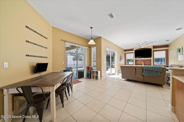 interior space with light tile patterned flooring, pendant lighting, ceiling fan, and a textured ceiling