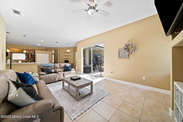 living room with ceiling fan, a textured ceiling, and light tile patterned floors