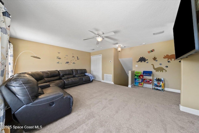 carpeted living room featuring ceiling fan and a textured ceiling