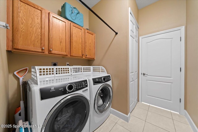 laundry room featuring cabinets, separate washer and dryer, and light tile patterned floors