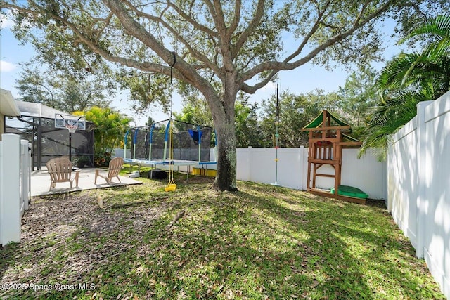 view of yard featuring a patio, a playground, and a trampoline