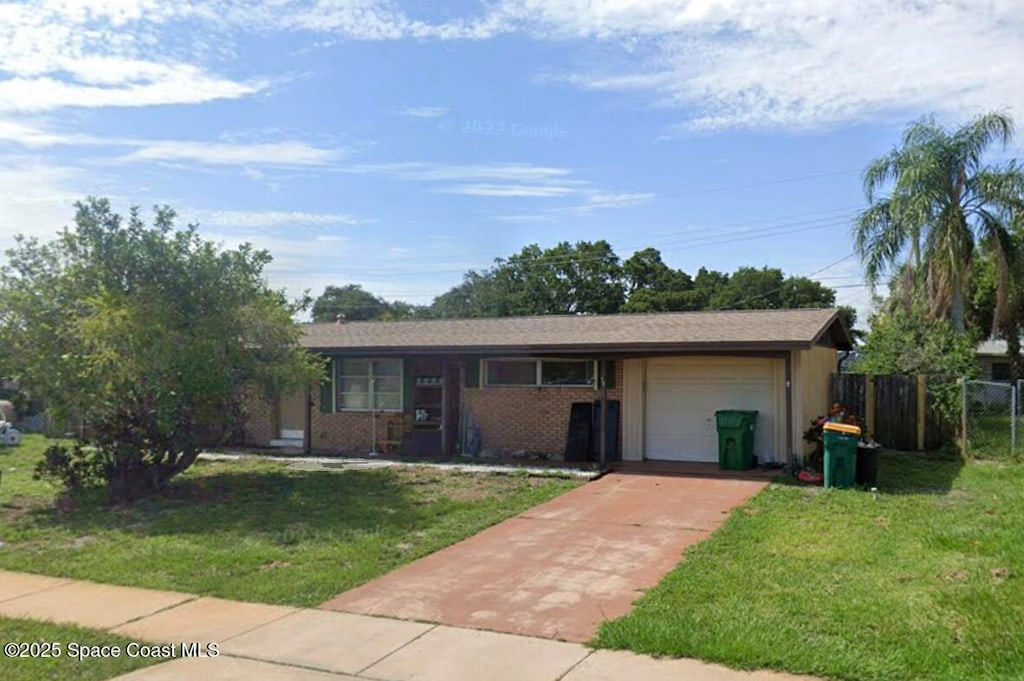 ranch-style house featuring a garage and a front lawn