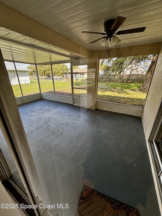 unfurnished sunroom with ceiling fan