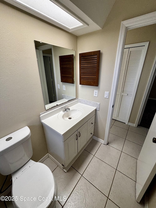 bathroom featuring vanity, toilet, and tile patterned flooring