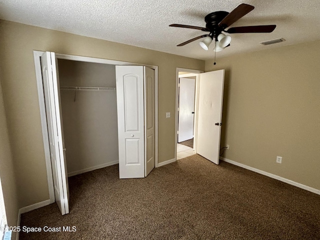 unfurnished bedroom with ceiling fan, carpet, a closet, and a textured ceiling