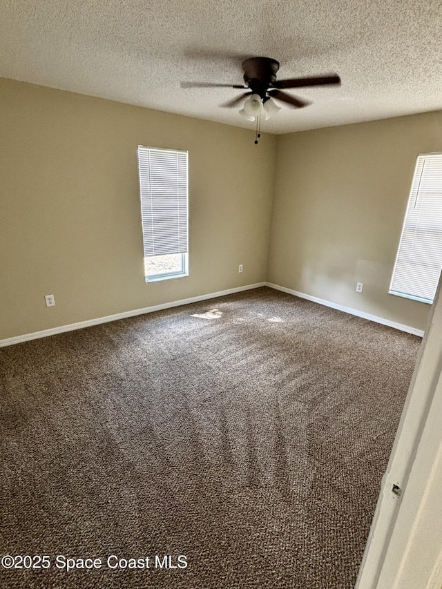 carpeted spare room with a textured ceiling and ceiling fan