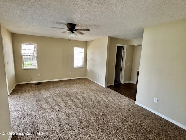 carpeted spare room featuring ceiling fan and a textured ceiling