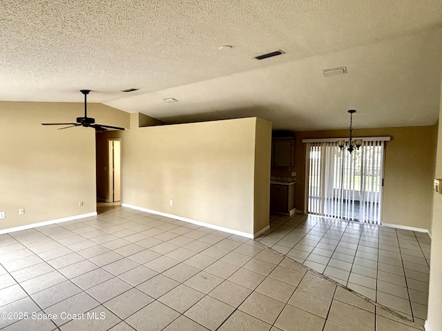 tiled empty room with lofted ceiling, ceiling fan with notable chandelier, and a textured ceiling