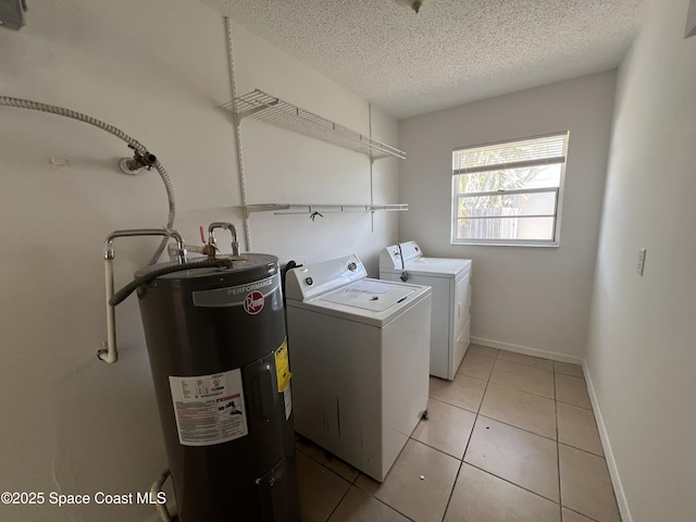 laundry room with washer and dryer, light tile patterned flooring, water heater, and a textured ceiling