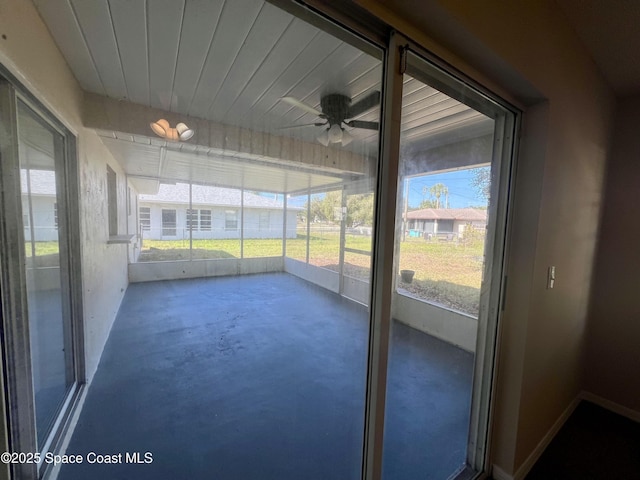 unfurnished sunroom with ceiling fan