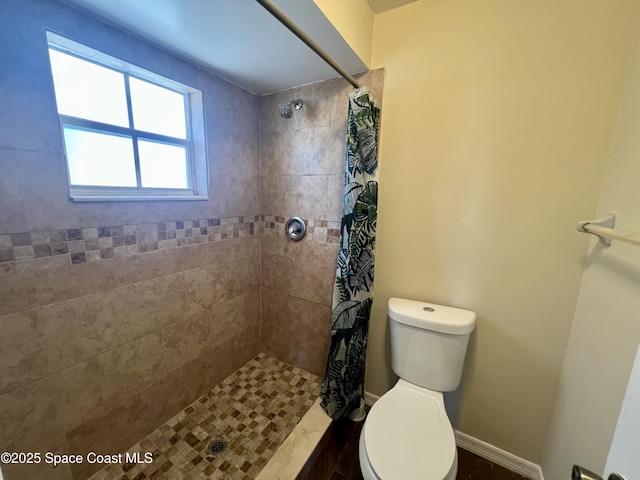 bathroom featuring toilet and a shower with shower curtain