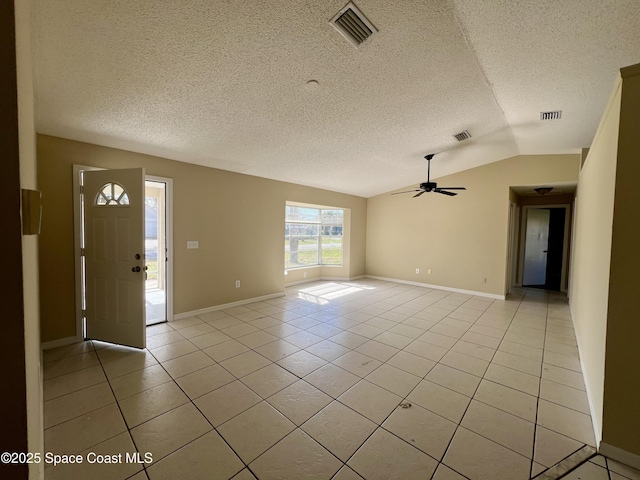 tiled entryway with vaulted ceiling, a textured ceiling, and ceiling fan