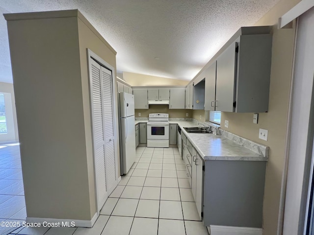 kitchen with sink, white appliances, light tile patterned floors, gray cabinetry, and a textured ceiling